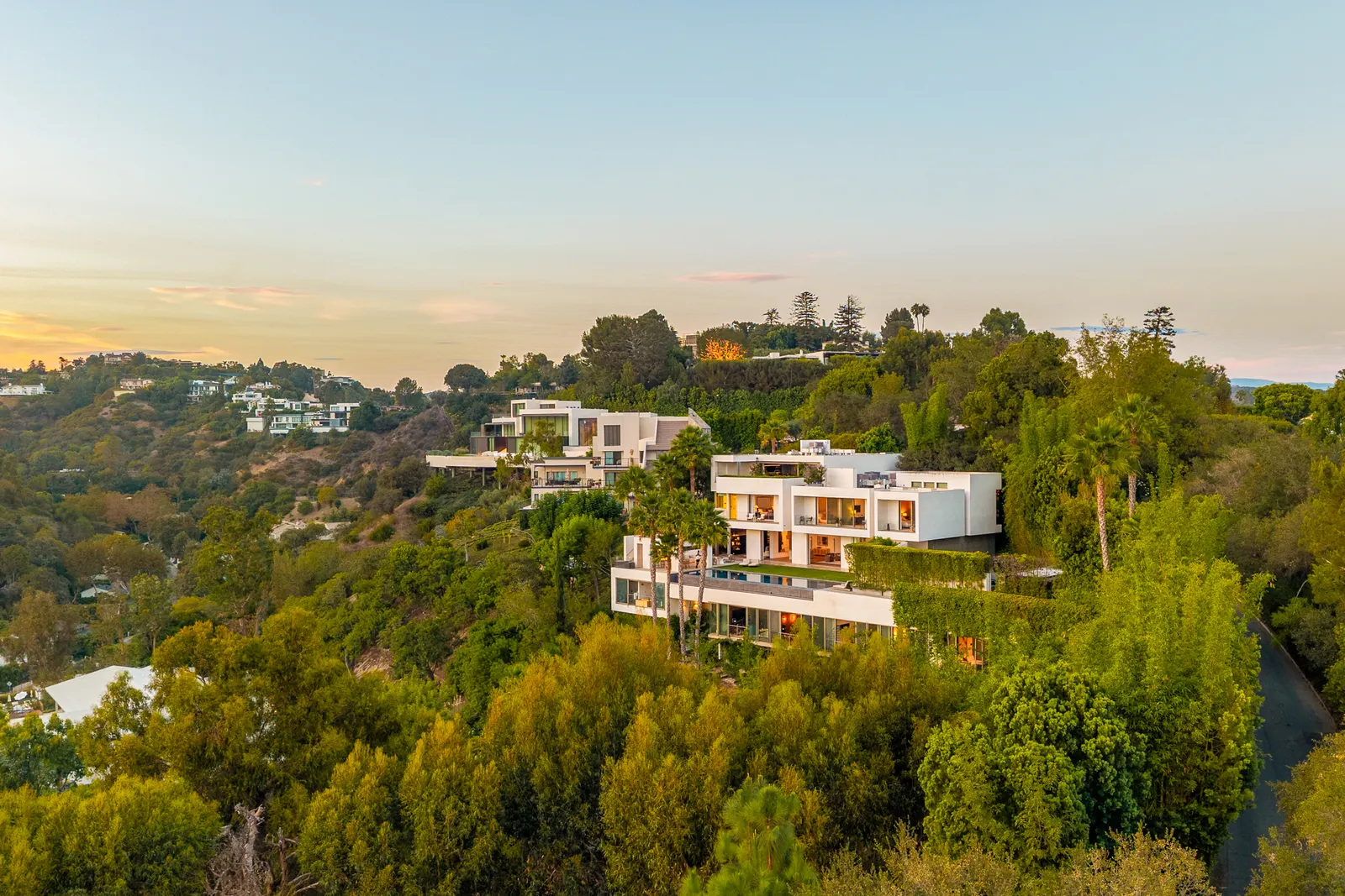 Aerial view of Stradella Residence at dusk, stepping down its wooded Bel Air hillside